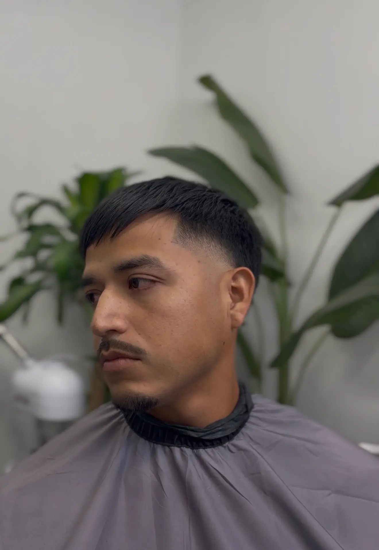 Short straight fringe with tapered sides, shown from the front and side